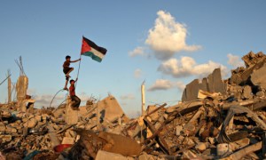 Palestinian children in Khan Yunis on the Gaza Strip place their national flag on the rubble of a bu